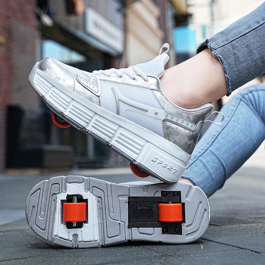 A woman wearing a pair of white roller skate sneakers with pop out heel wheels, shown in an outdoor urban setting