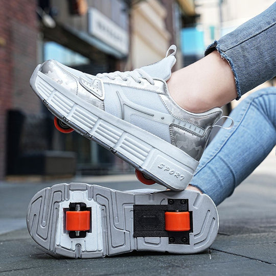 A woman wearing a pair of white roller skate sneakers with pop out heel wheels, shown in an outdoor urban setting