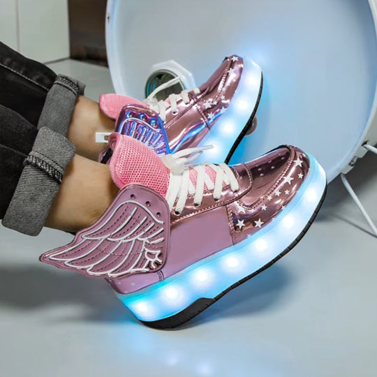 Pink LED roller sneakers with wing design worn by a person, on a light background