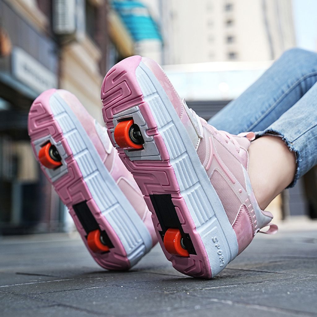 Pink roller skate shoes with wheels and white soles, shown on a person's feet in a city street setting