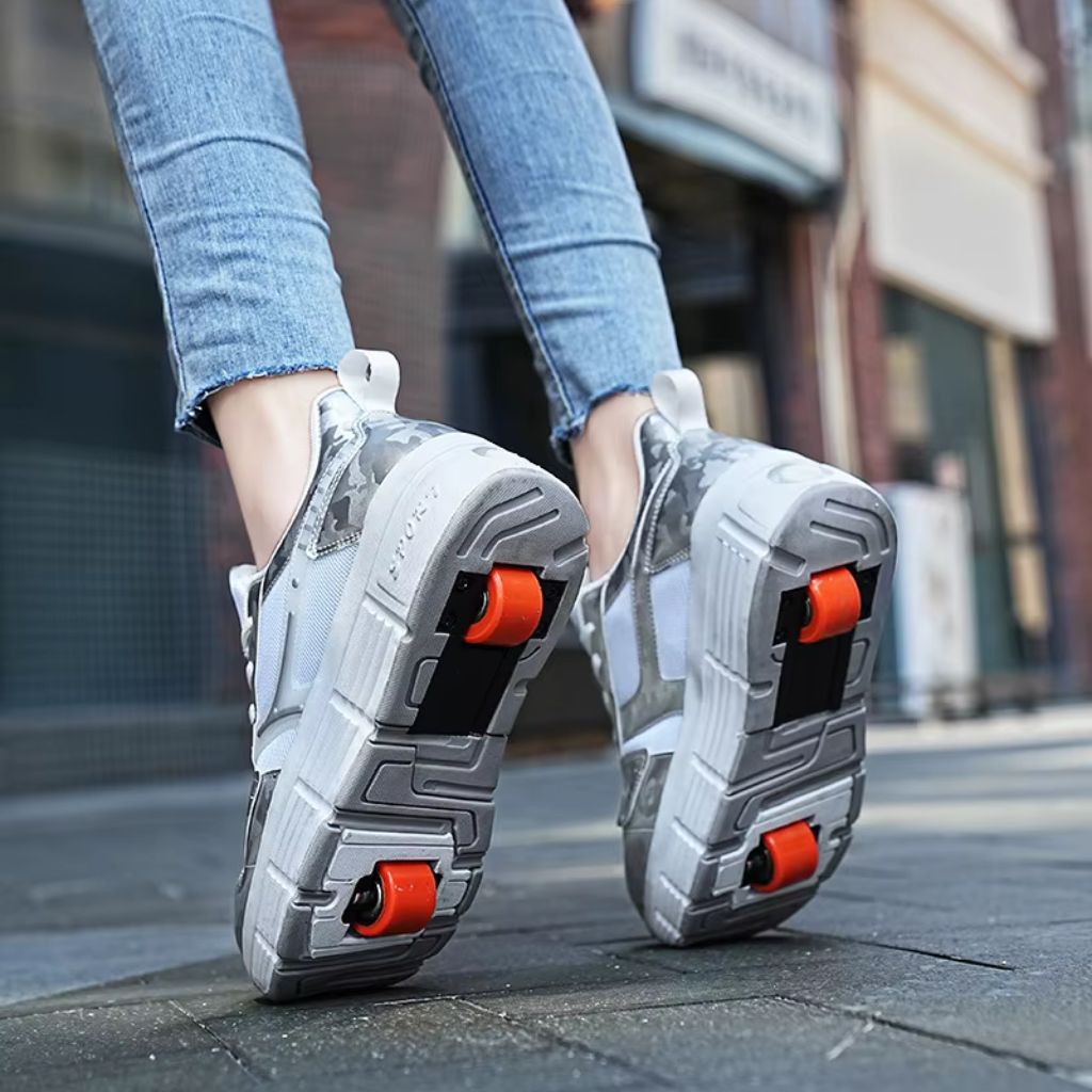 A woman wearing chunky white roller skate shoes with wheels, shown from the knees down on a city sidewalk