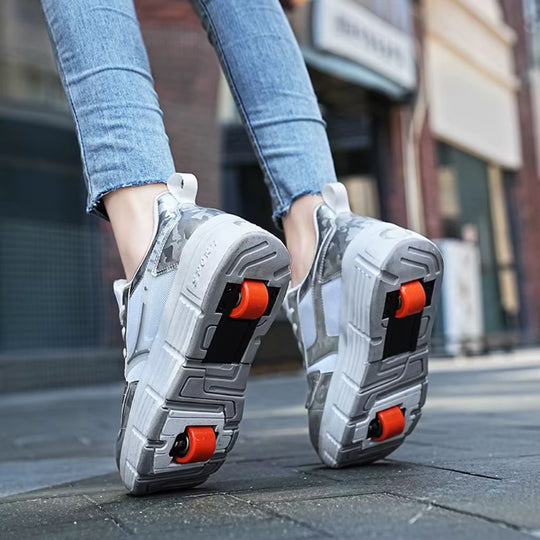 A woman wearing chunky white roller skate shoes with wheels, shown from the knees down on a city sidewalk