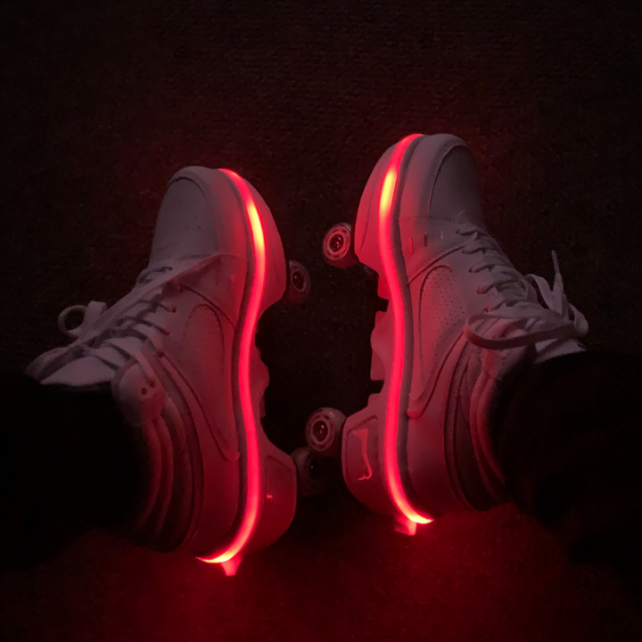 Kick Speed LED roller shoes with retractable wheels glowing red during night ride