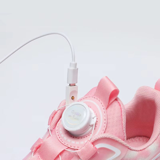 Close-up of a pink shoes with wheel and charging cable on a light gray background